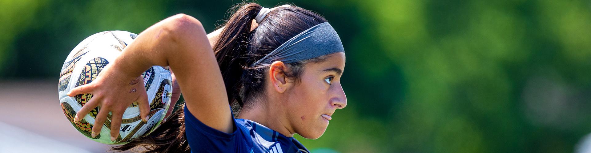 Female player getting ready to throw soccer ball