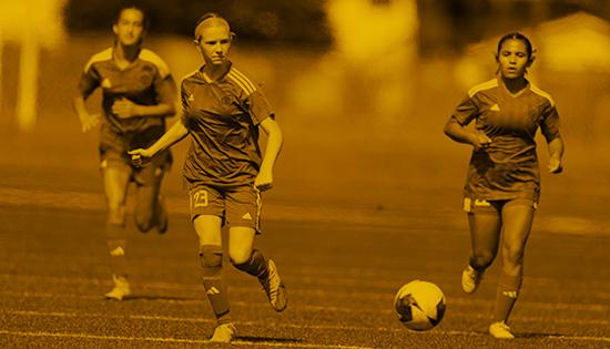 3 female players, running for soccer ball