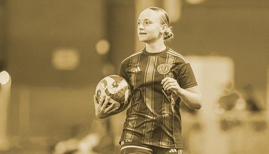 Female player with soccer ball in arms